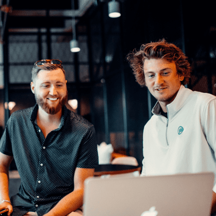 Mobile Banner Image showing two colleagues smiling around a laptop in a bright office, representing Material's customer experience consulting.